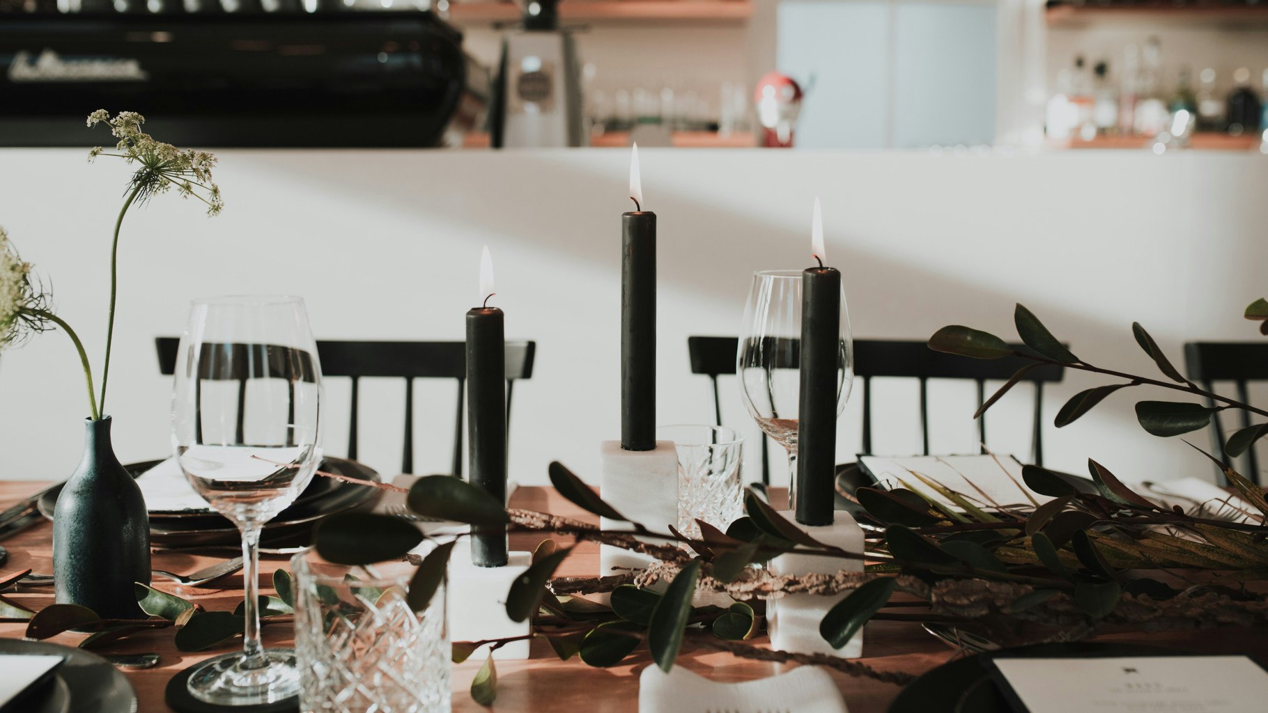 Black candles as part of a wedding table setting.